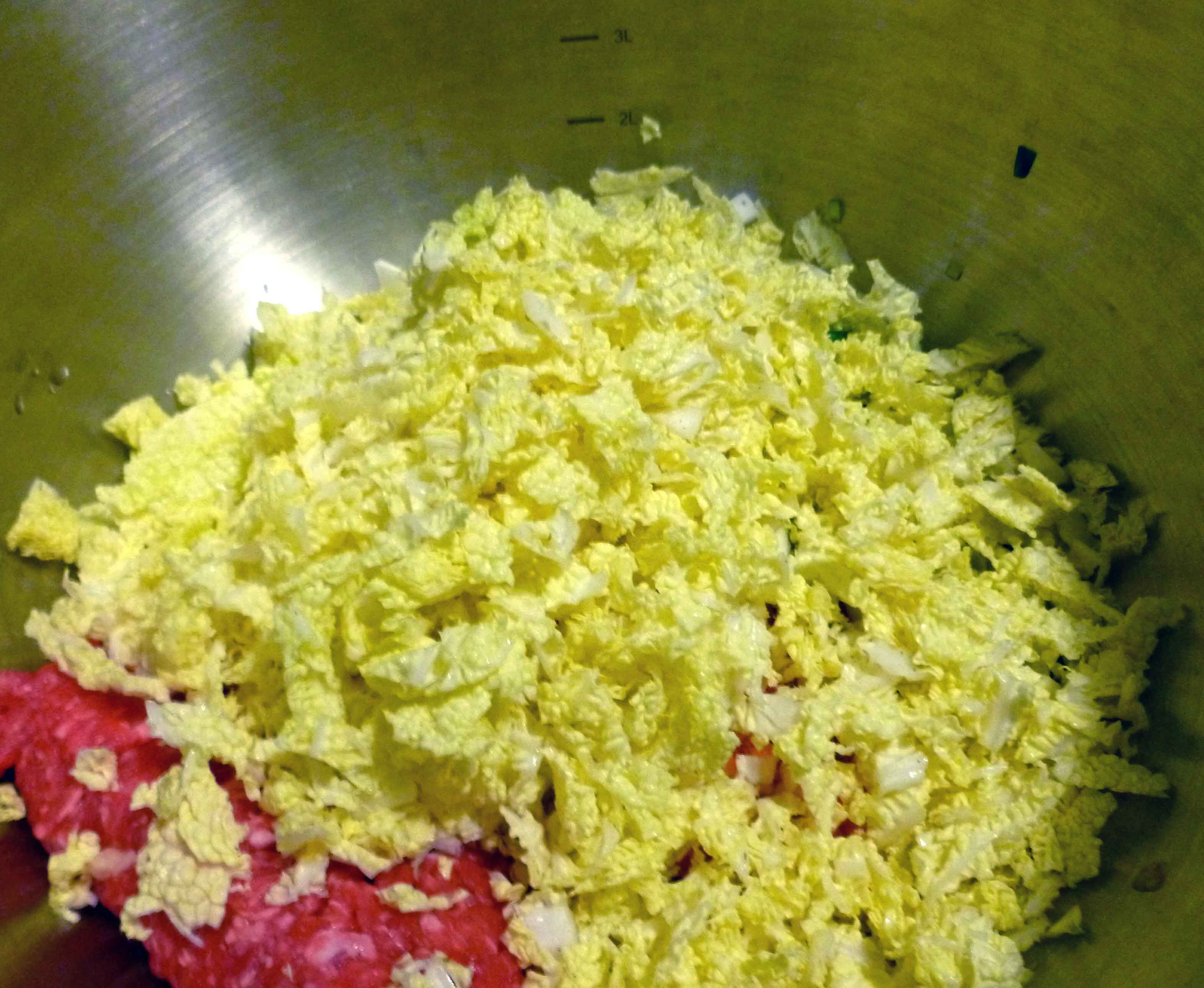 Shredded Napa cabbage in bowl with other ingredients