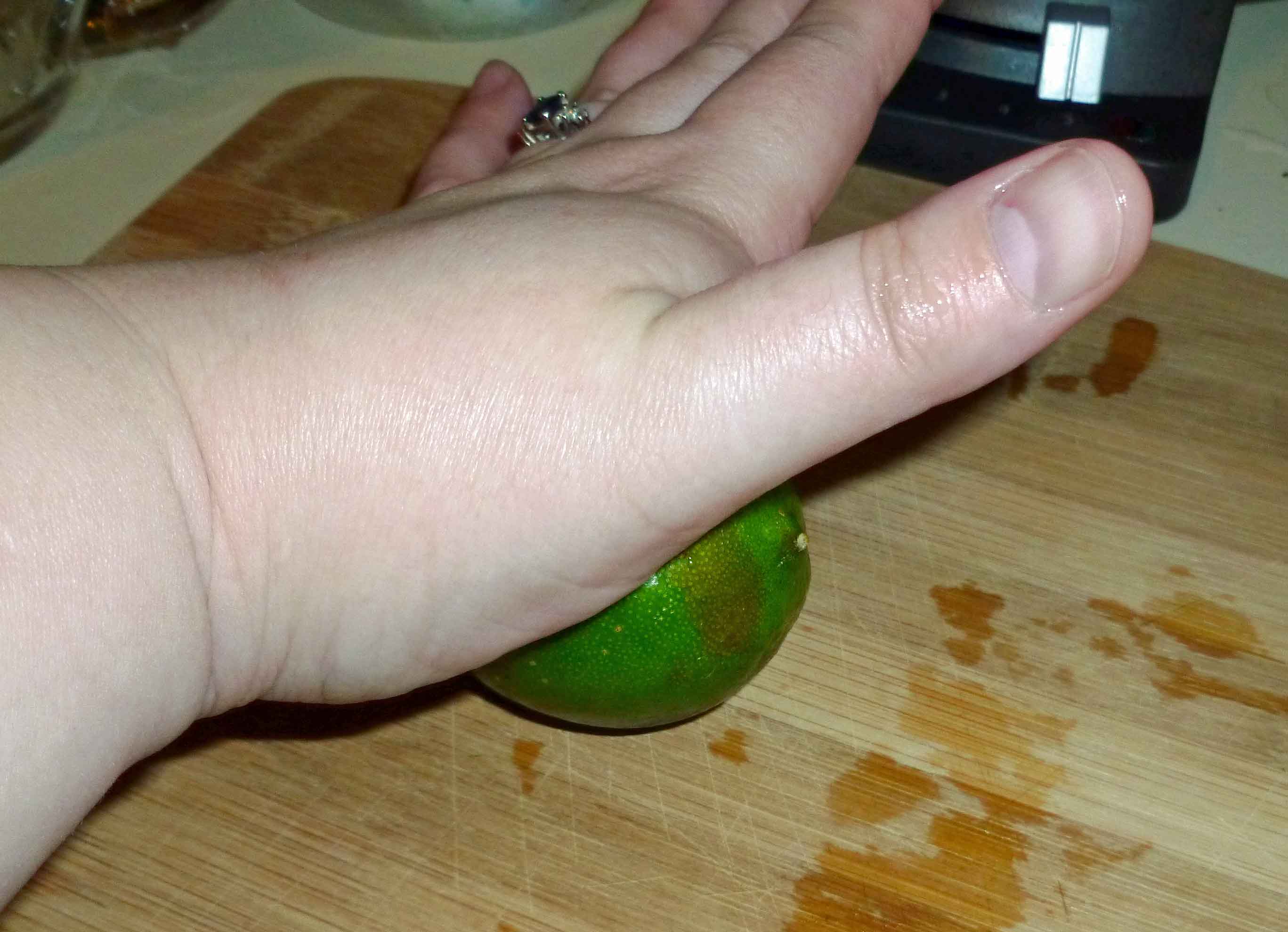 Denise awkwardly rolling limes with her left while she takes pictures with her right