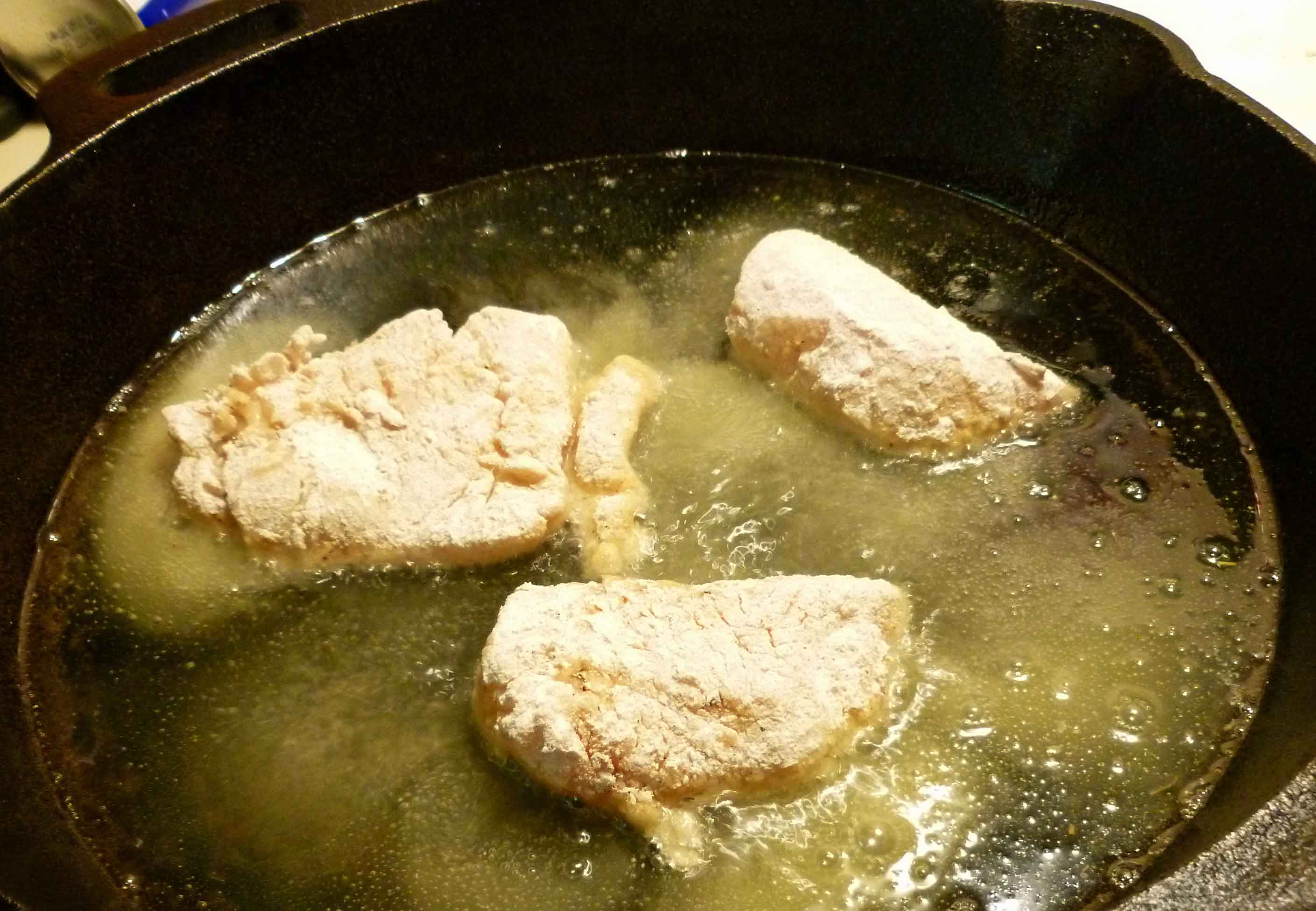 Haddock pieces frying in skillet