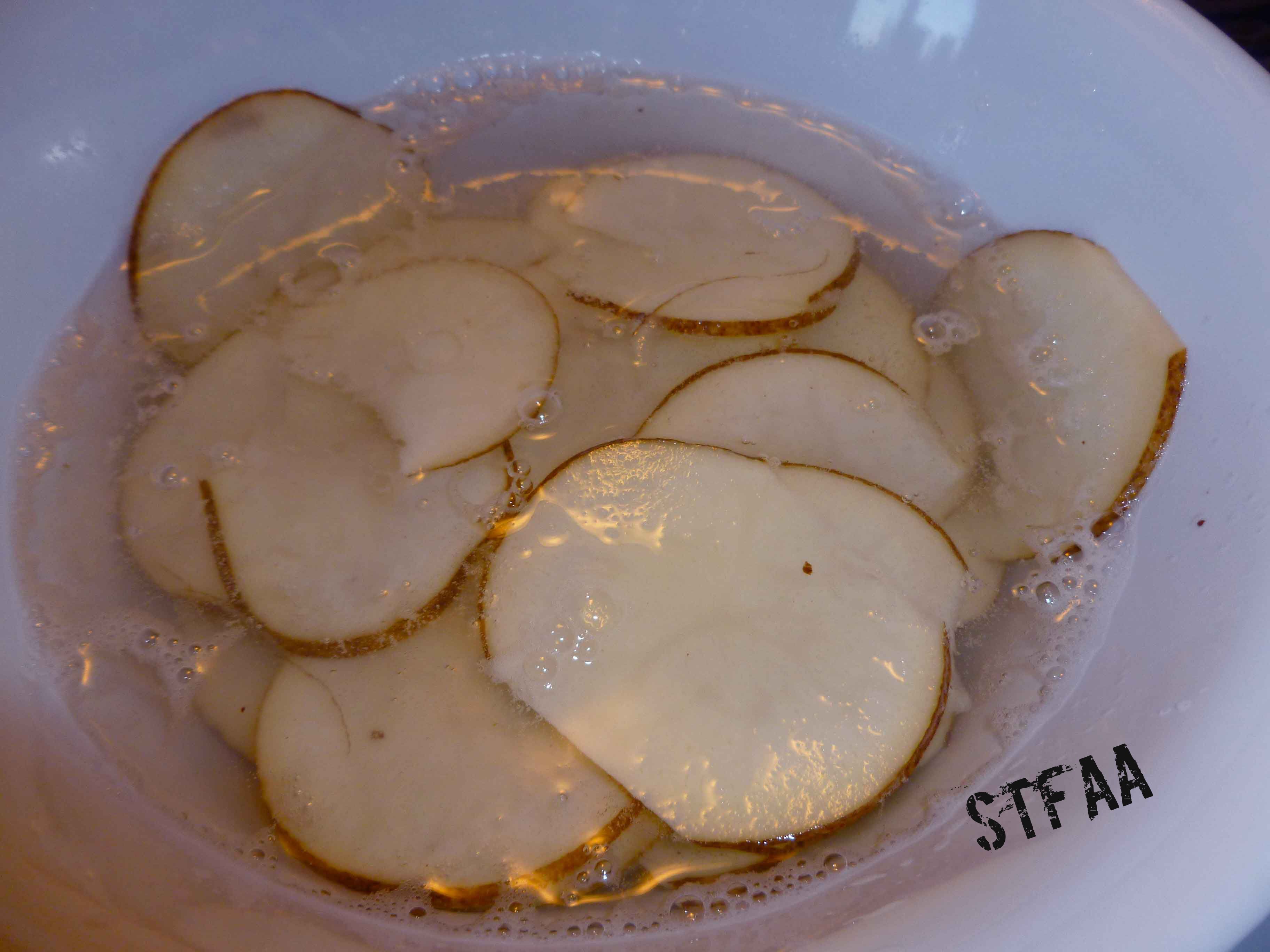 Rinsing off the starch from the Russet potato slices