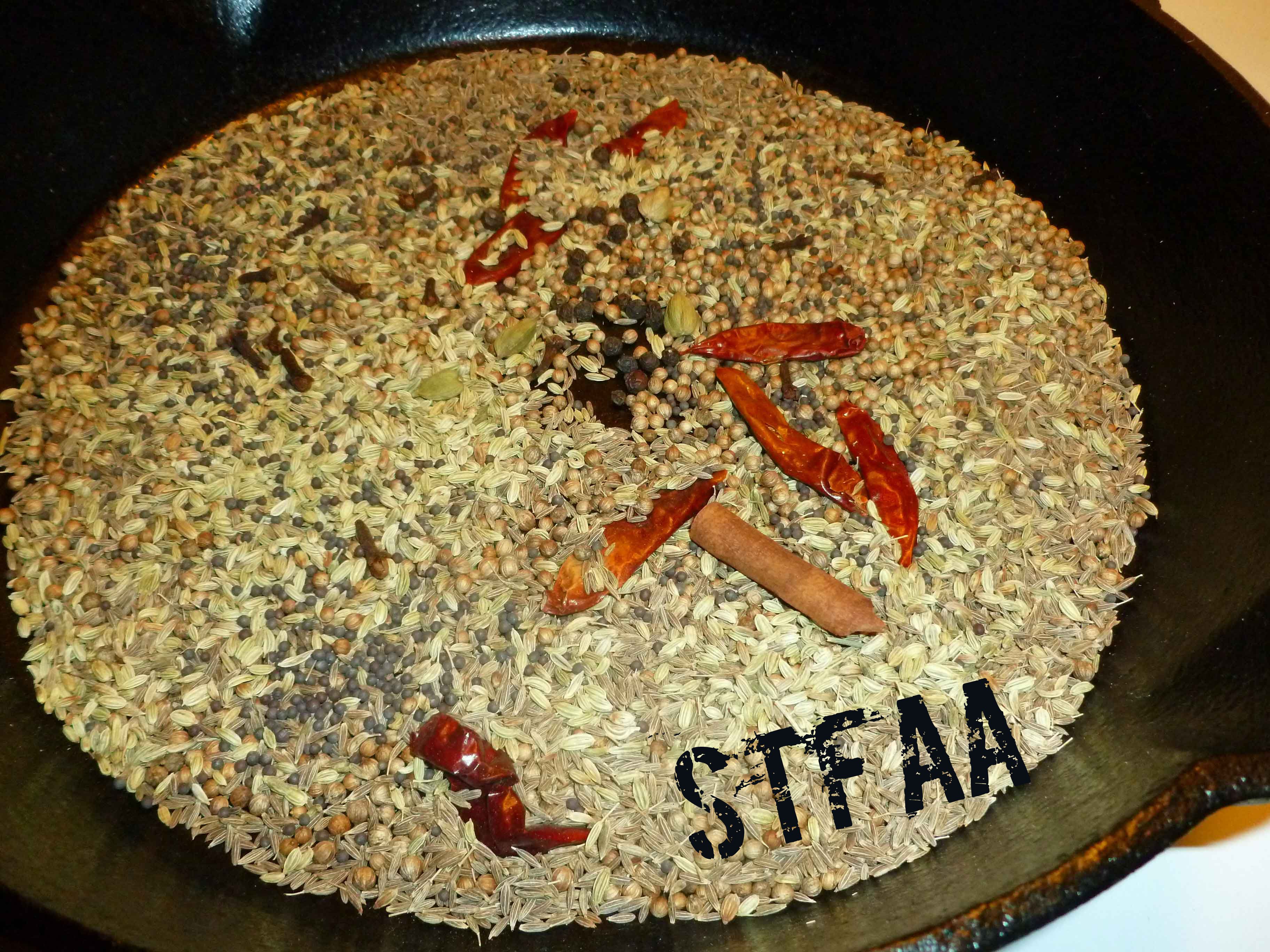 Seeds, spices, and chiles in skillet before toasting