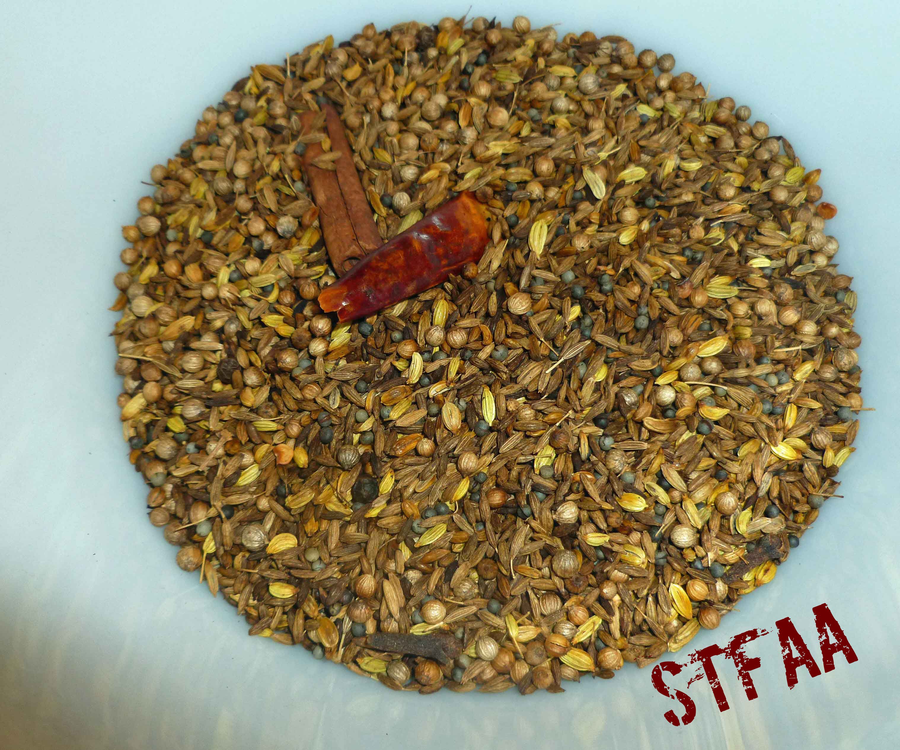 Seeds, spices, and chiles in bowl after toasting