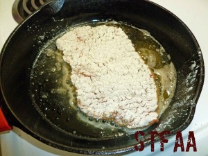 Cube steak cooking in skillet