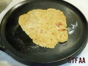 Tortilla cooking on cast iron skillet