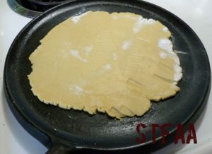 Tortilla after being flipped on skillet from parchment paper