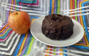 Chocolate Mini Bundt Cake with Chocolate Cinnamon Frosting with an apple for size comparison