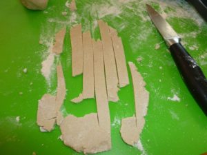 Hand rolling and cutting fettuccine noodles