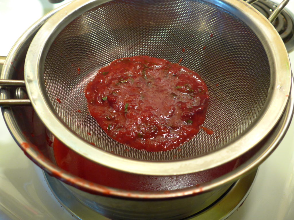 Straining the basil-plum sauce