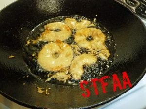 Apples being deep fried in oil