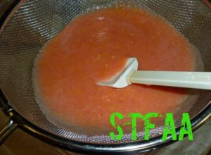 Peppers, grapefruit pulp, and garlic in strainer